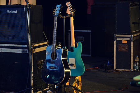 two guitar hanging near speakers thumbnail