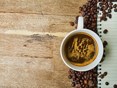 white ceramic mug with coffee surrounded coffee beans thumbnail