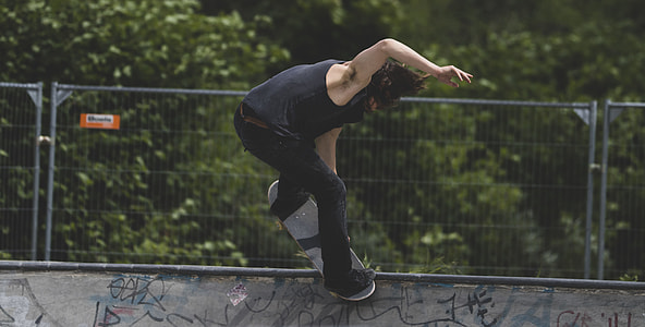 man in black tank top and pants playing skateboard thumbnail
