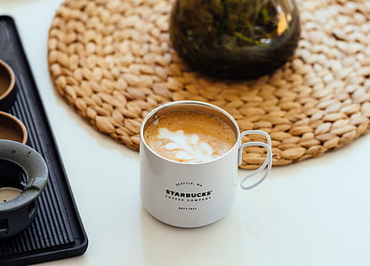 white Starbucks mug filled with coffee beside black serving tray thumbnail