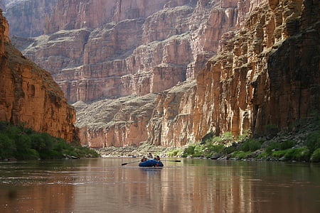 person riding on boat between mountains thumbnail