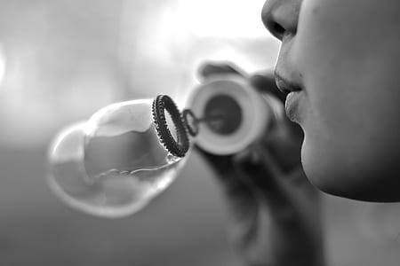 grayscale photography of person blowing bubbles thumbnail