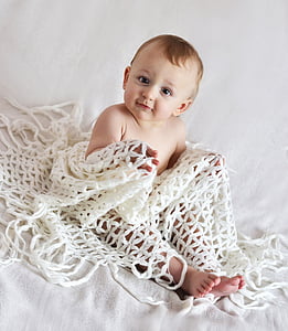 baby covered by knitted blanket thumbnail