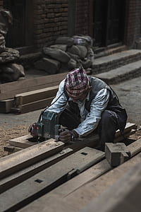 man in white dress shirt using gray power tool thumbnail