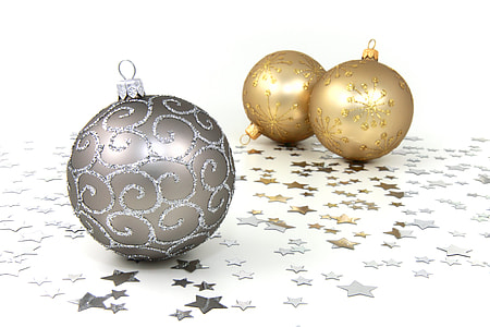 grey glitter bauble near two yellow glitter baubles on white and grey star print surface thumbnail