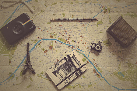 eiffel tower miniature beside cameras on map board thumbnail