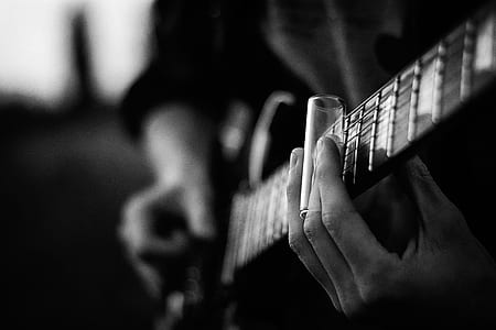 selective focus photography of person playing guitar thumbnail