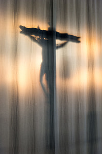 silhouette of crucifix on white textile thumbnail
