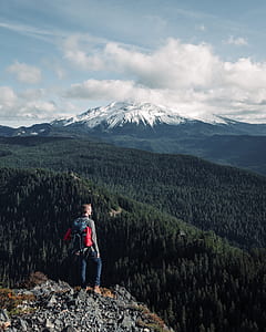 shallow focus photography of man standing on cliff thumbnail