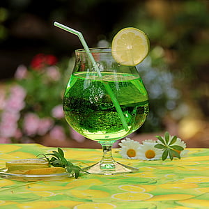 clear footed glass filled with green liquid thumbnail