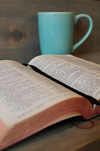 opened book with black string beside teal ceramic mug thumbnail