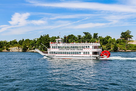 white and orange ship near beige and green island during daytime thumbnail