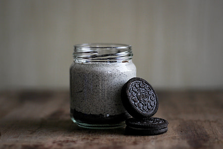 shallow focus photography of two chocolate biscuits leaning on clear glass bottle thumbnail