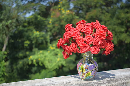 Artificial Roses in Clear Glass Vase on Concrete Surface thumbnail