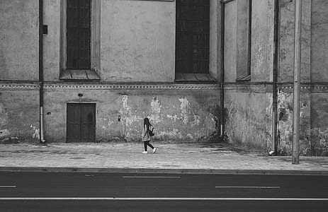 Gray Scale Photography of Woman Walking Near High Rise Building thumbnail