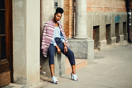 Woman Sitting on Gray Concrete Pillar thumbnail