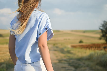 shallow focus photography of woman standing on green field thumbnail