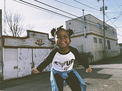girl standing on road on front of white Ace building thumbnail