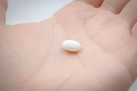 person holding white pill thumbnail