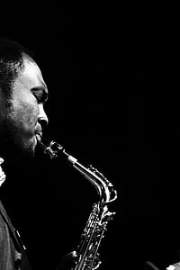 grayscale photo of man playing saxophone thumbnail