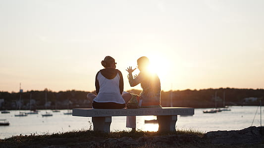 two person sitting on bench while talking at each other thumbnail