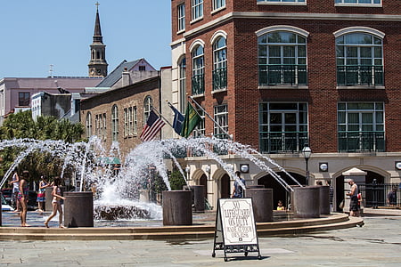 people standing on fountain beside building at daytime thumbnail