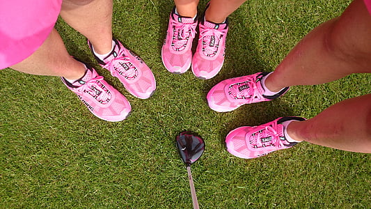 three person wearing pink athletic shoes standing on grass field thumbnail
