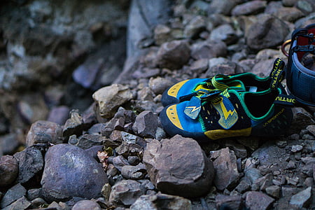 pair of green-yellow-and-blue hiking sandals on rocks thumbnail