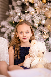 girl wearing blue sleeveless dress and holding white bear plush toy thumbnail