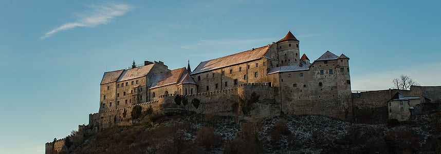 photo of brown castle on mountain beside a cliff thumbnail