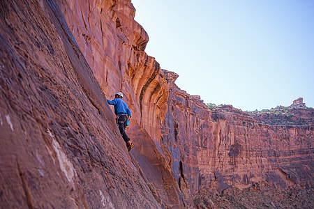 person climbing on mountain during daytime thumbnail