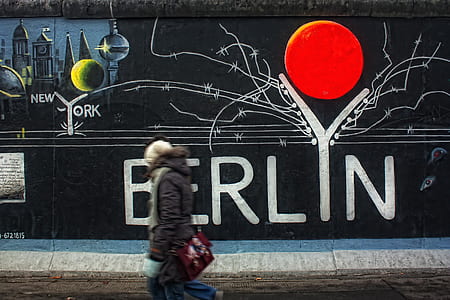 person walking on road against mural painted wall thumbnail