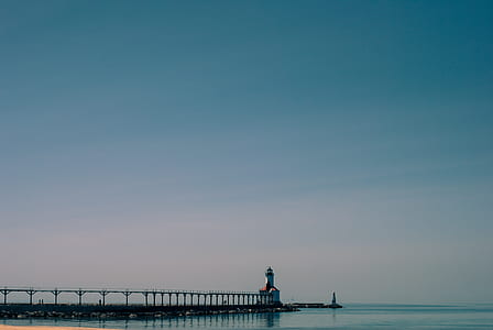 white lighthouse beside a body of water thumbnail