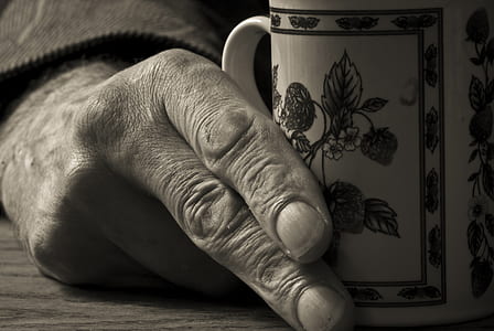 grayscale photo of person holding mug thumbnail