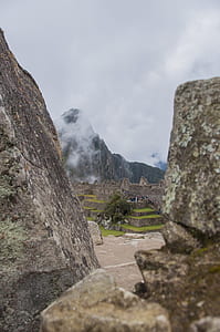 people gathering near concrete building in distant of mountain thumbnail