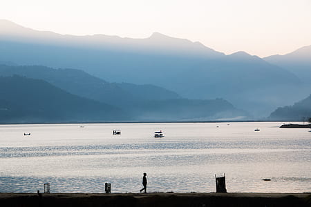 person walking beside sea and mountain thumbnail