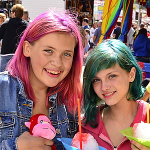 two women standing behind group of people thumbnail