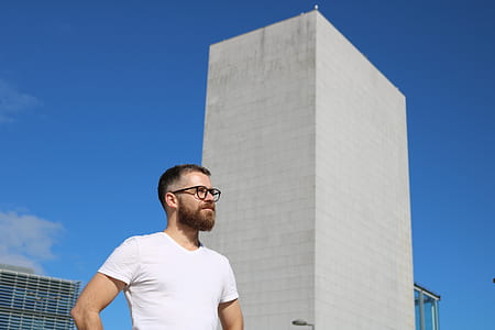 man standing beside building during daytime thumbnail