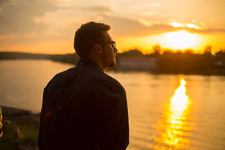 man standing while watching view of body of water thumbnail
