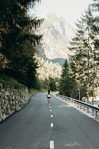 woman standing center of road during day time thumbnail