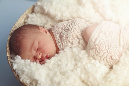baby in white bed sheet thumbnail