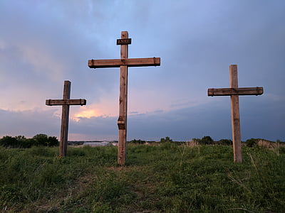 three brown wooden cross on grass hill thumbnail