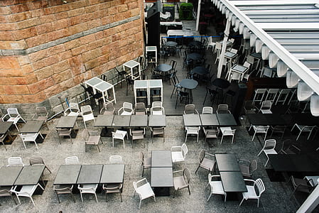 empty tables and chairs outside building thumbnail