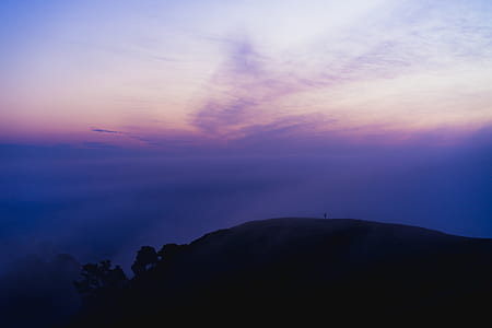 photo of person standing on mountain thumbnail