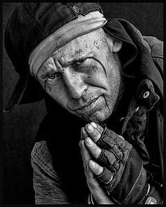 Man in Black Hat Gloves and Jacket Holding Hands Together Greyscale Photo thumbnail