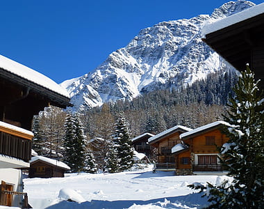 village at side of mountain covered by snow thumbnail