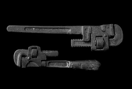 two gray pipe wrenches on black surface thumbnail