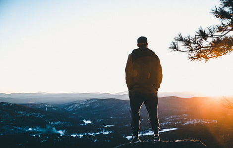 man standing on rock overlooking valley during daytime thumbnail