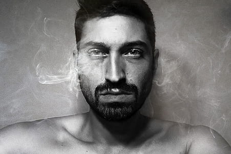 gray scale photo of man sitting near wall thumbnail