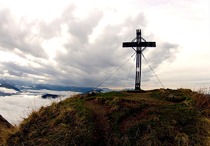 black standing cross on mountain top thumbnail
